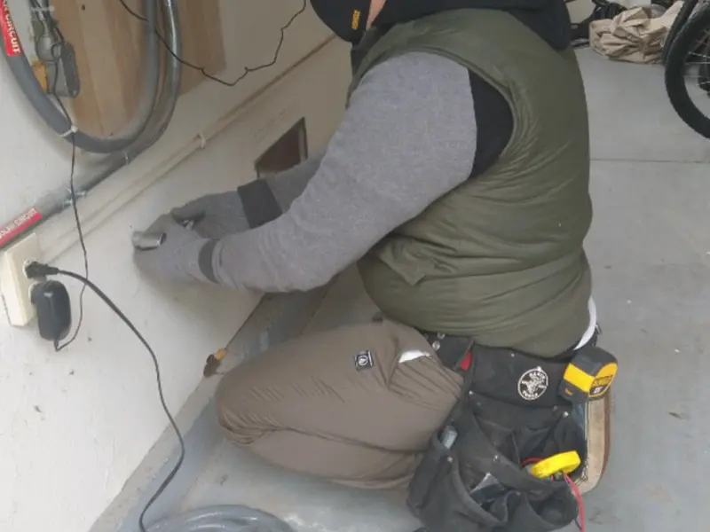 Electrician performing outlet wiring in a Odessa garage